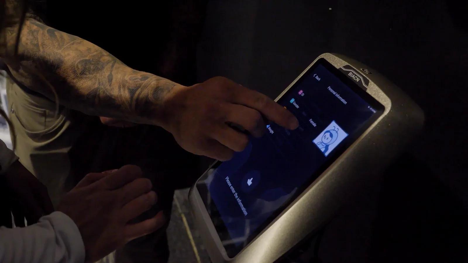 Member entering their details on the touchscreen of a body composition scanner at Inception Gym Christchurch