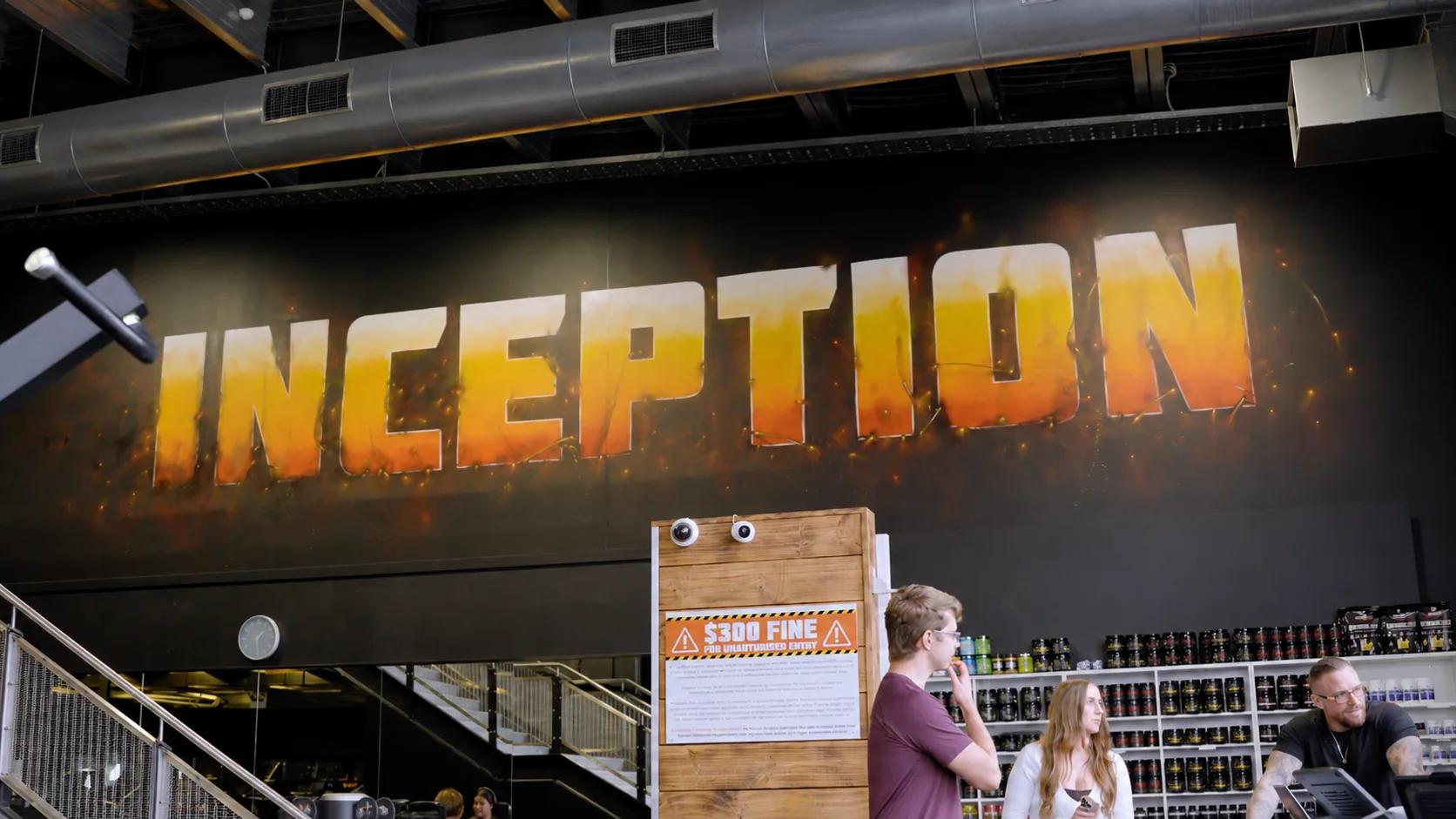 Members by the supplement store beneath the large flame-styled INCEPTION mural at Inception Gym Christchurch, Tower Junction